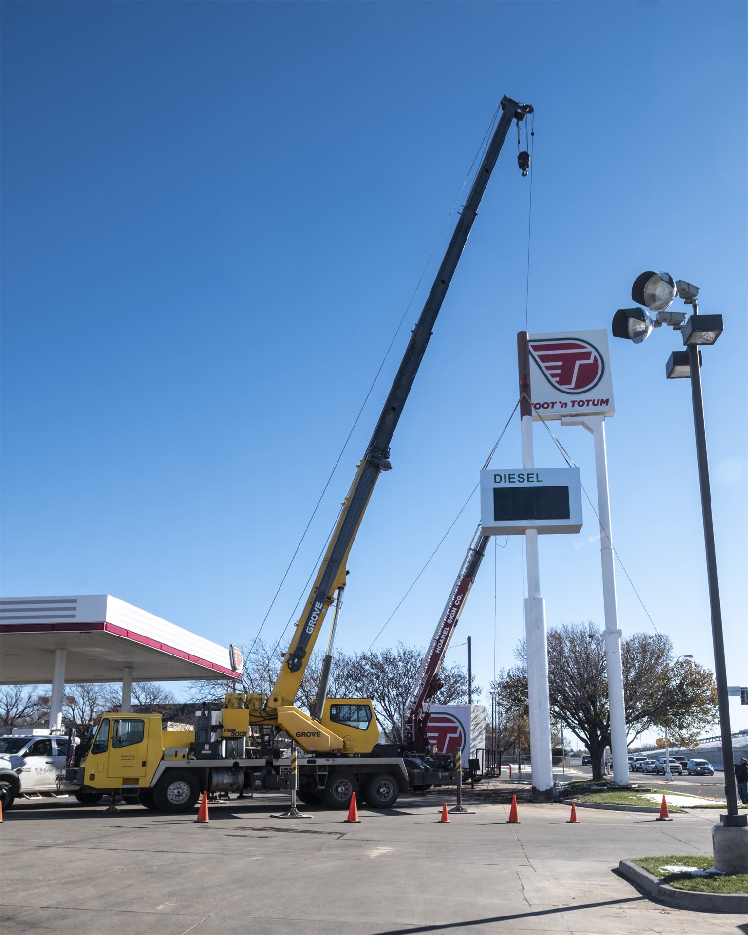 Crane installing fuel station sign