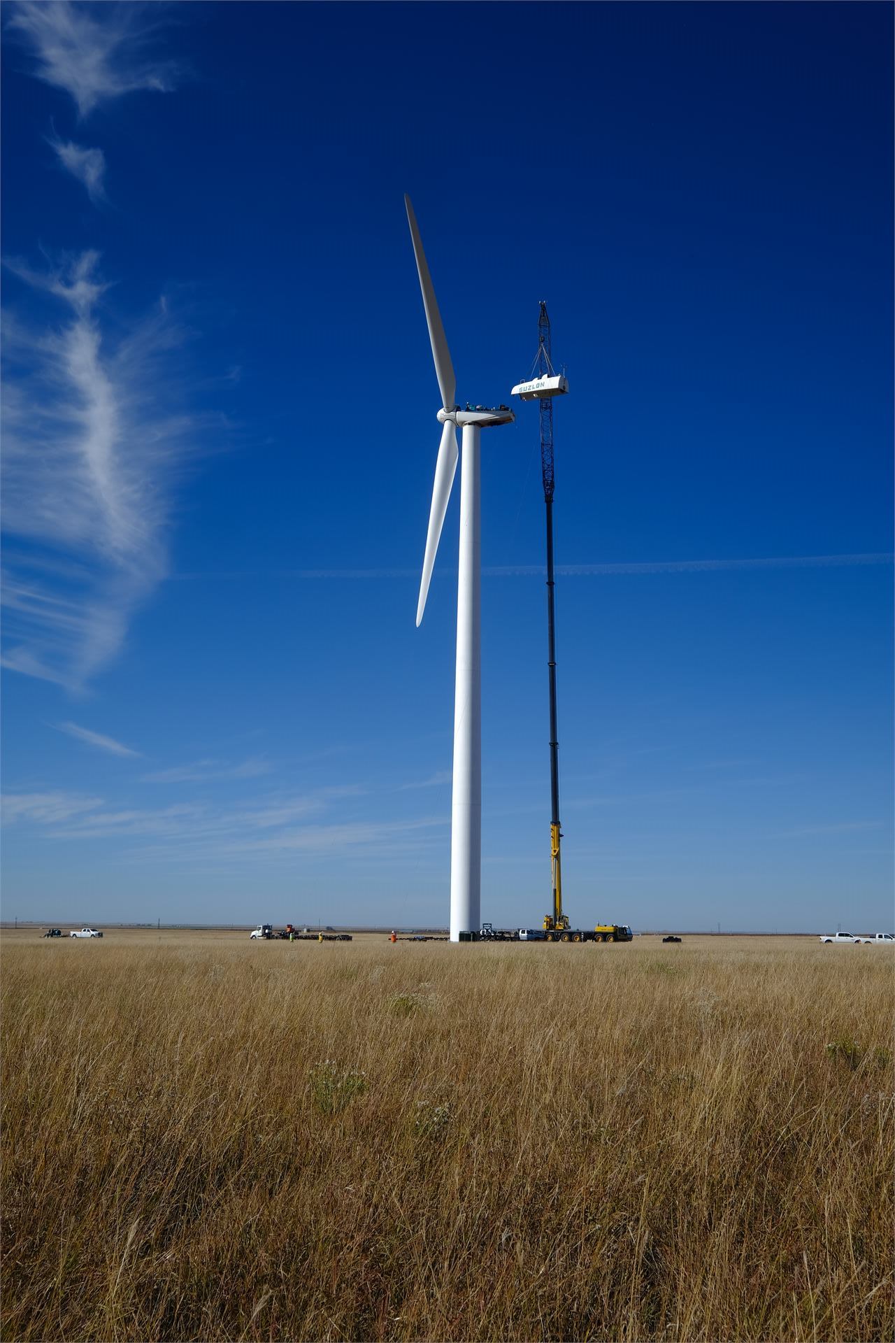 Crane lifting nacelle near wind turbine